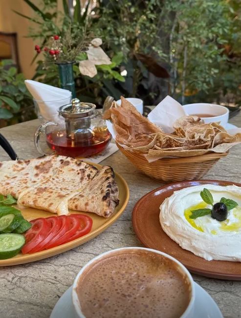 Coffee and manakish plate on a garden table at BEYt